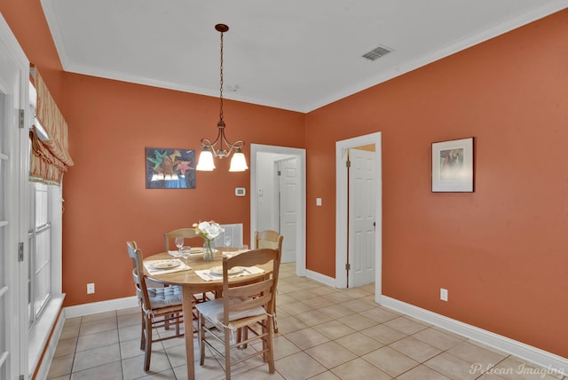 dining area featuring crown molding, light tile patterned floors, and a chandelier