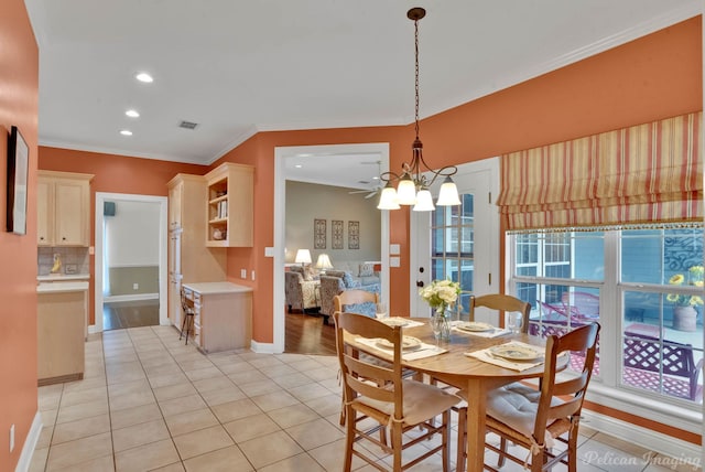 tiled dining space featuring ornamental molding and a notable chandelier