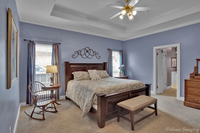 bedroom with ornamental molding, light colored carpet, and a tray ceiling