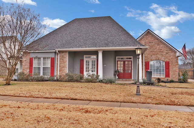 view of front of home featuring a porch, a front yard, and french doors