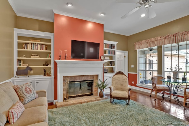 living room featuring crown molding, hardwood / wood-style floors, ceiling fan, and built in shelves