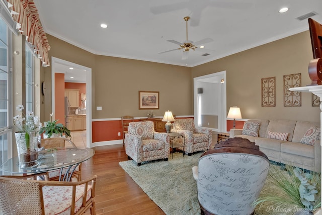 living room featuring ornamental molding, ceiling fan, and light hardwood / wood-style floors