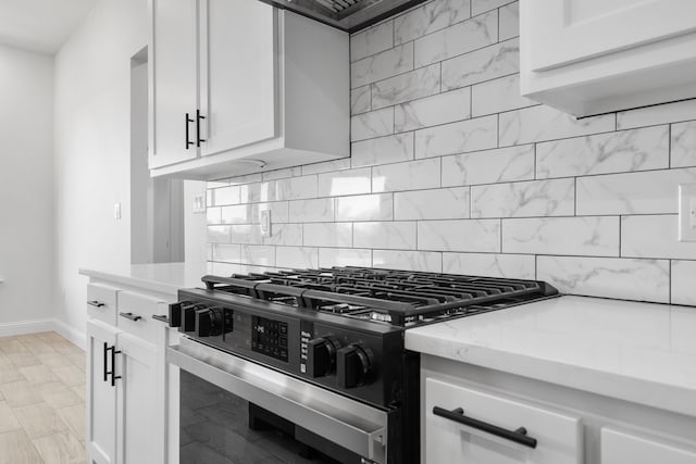 kitchen featuring white cabinetry, backsplash, and stainless steel gas stove