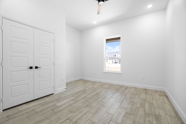 empty room with ceiling fan and light hardwood / wood-style floors