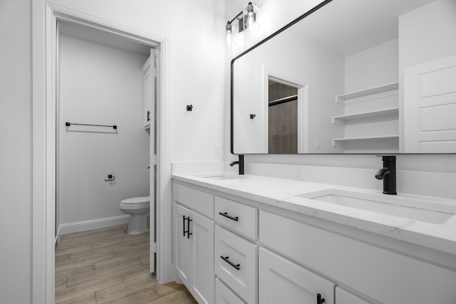 bathroom with vanity, wood-type flooring, and toilet