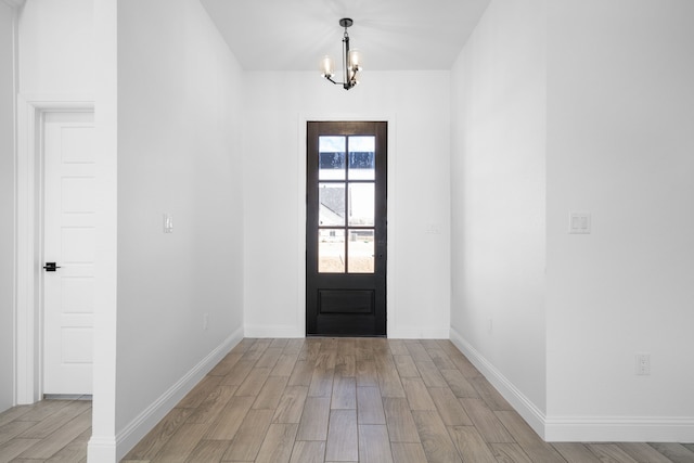 entryway featuring an inviting chandelier and light hardwood / wood-style flooring