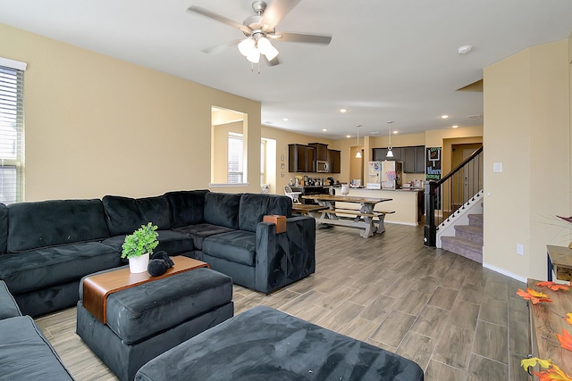 living room with ceiling fan and light wood-type flooring