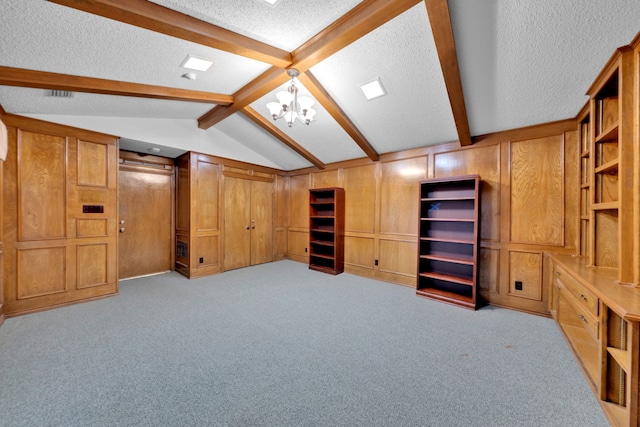 interior space featuring a notable chandelier, lofted ceiling with beams, a textured ceiling, light carpet, and wood walls