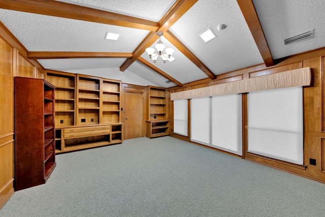 unfurnished living room with an inviting chandelier, carpet floors, lofted ceiling with beams, and a textured ceiling