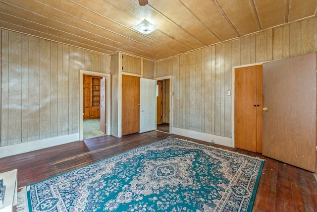 unfurnished room with dark hardwood / wood-style floors, wooden ceiling, and wooden walls