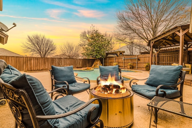 patio terrace at dusk featuring a fire pit and a gazebo