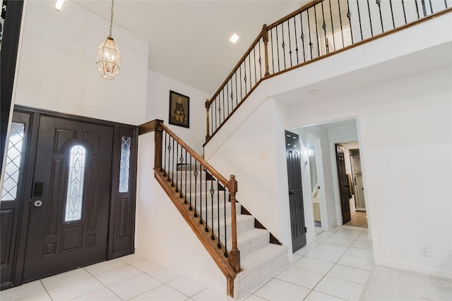 foyer entrance with a notable chandelier, light tile patterned floors, and a high ceiling