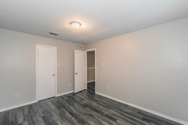 unfurnished room with dark wood-type flooring