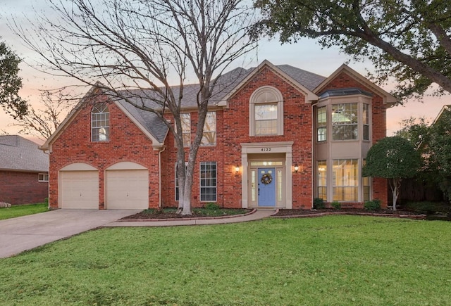 view of front of home with a yard and a garage