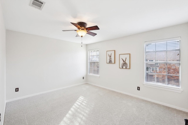 carpeted spare room featuring ceiling fan