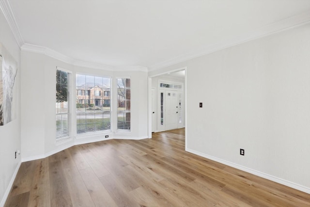 unfurnished room featuring ornamental molding and light wood-type flooring