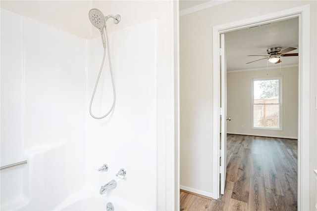 bathroom featuring crown molding, hardwood / wood-style floors, ceiling fan, and shower / bathing tub combination