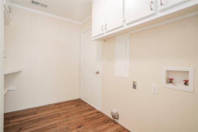 washroom with crown molding, cabinets, hookup for a washing machine, electric dryer hookup, and hardwood / wood-style floors