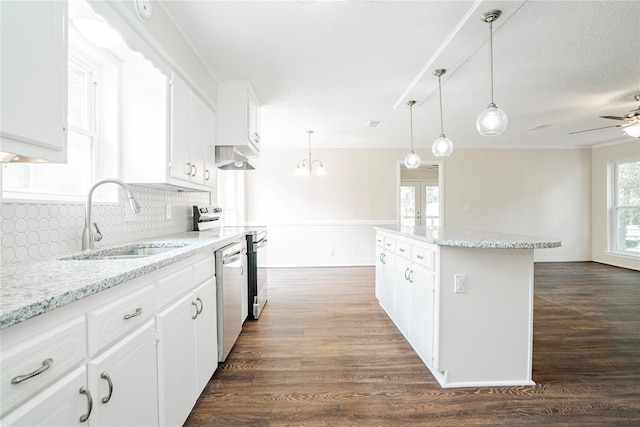 kitchen with appliances with stainless steel finishes, sink, pendant lighting, and white cabinets