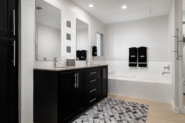 full bath featuring a sink, visible vents, a bath, tile patterned floors, and double vanity