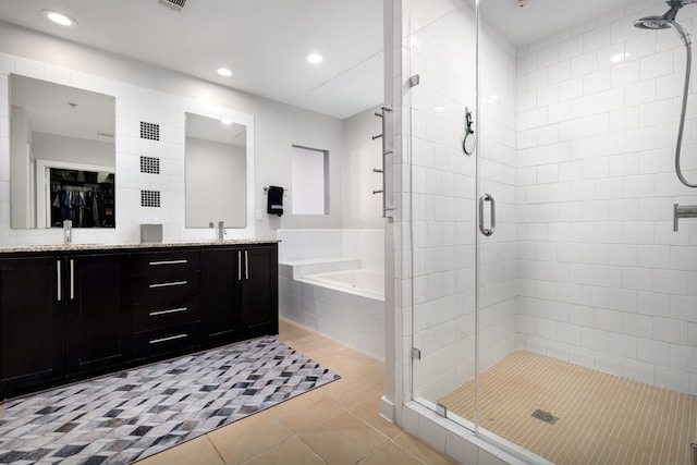 full bathroom featuring double vanity, a sink, a shower stall, tile patterned flooring, and a bath