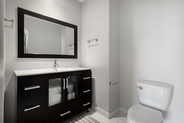 bathroom featuring vanity, toilet, and baseboards