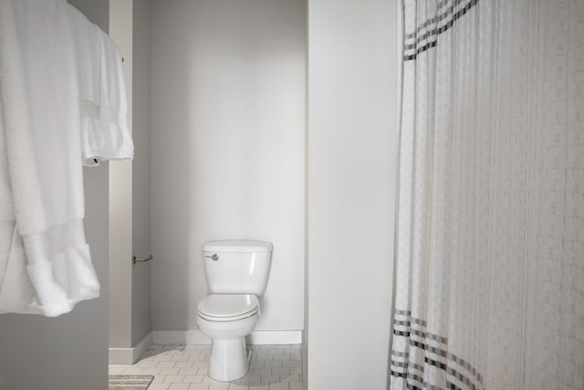 full bathroom with a shower with shower curtain, tile patterned flooring, toilet, and baseboards