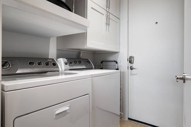 laundry area with cabinet space, light tile patterned floors, and separate washer and dryer