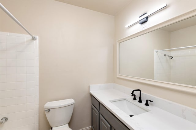 bathroom featuring tiled shower, vanity, and toilet