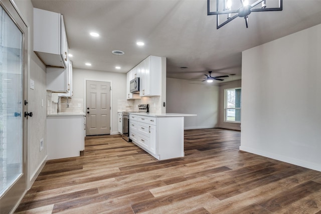 kitchen featuring tasteful backsplash, stainless steel appliances, light wood-type flooring, and white cabinets