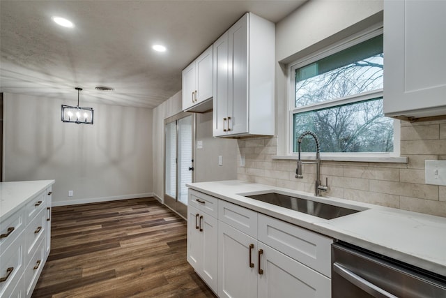 kitchen featuring pendant lighting, sink, dark wood-type flooring, dishwasher, and white cabinetry