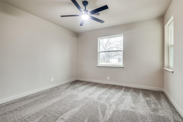 carpeted spare room featuring ceiling fan