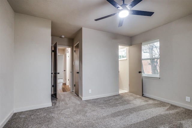 carpeted spare room featuring ceiling fan