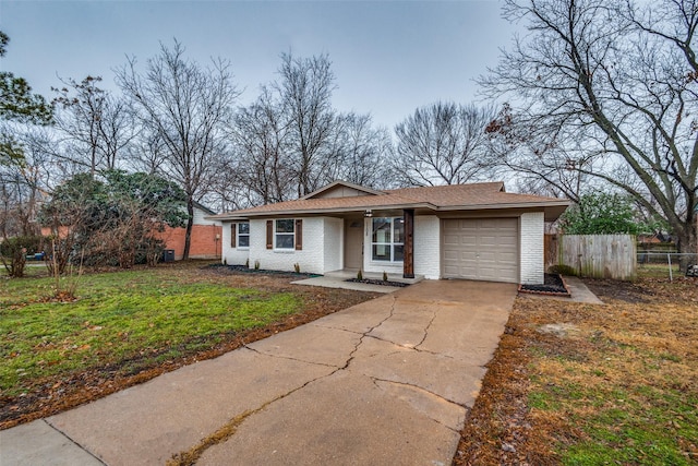 ranch-style home featuring a garage and a front lawn