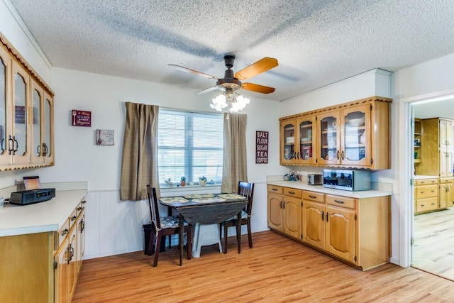 kitchen with ceiling fan, a textured ceiling, and light wood-type flooring