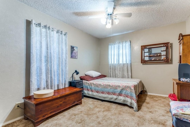 carpeted bedroom with ceiling fan and a textured ceiling