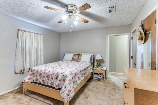 carpeted bedroom with ceiling fan and a textured ceiling