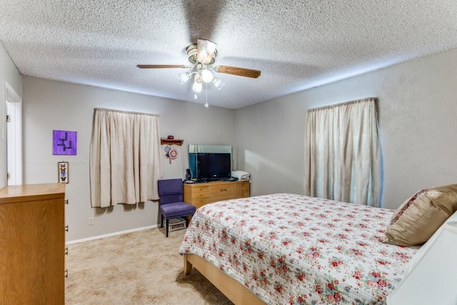 bedroom with light carpet, ceiling fan, and a textured ceiling