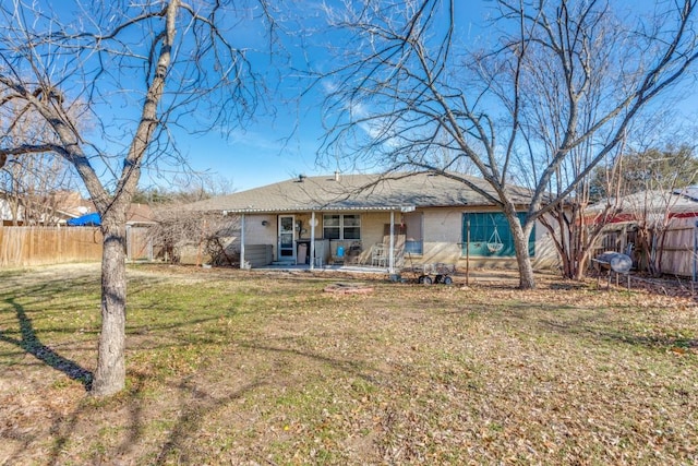 rear view of house with a lawn and a patio