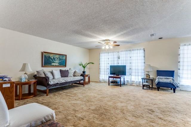 living room with carpet floors, a textured ceiling, and ceiling fan