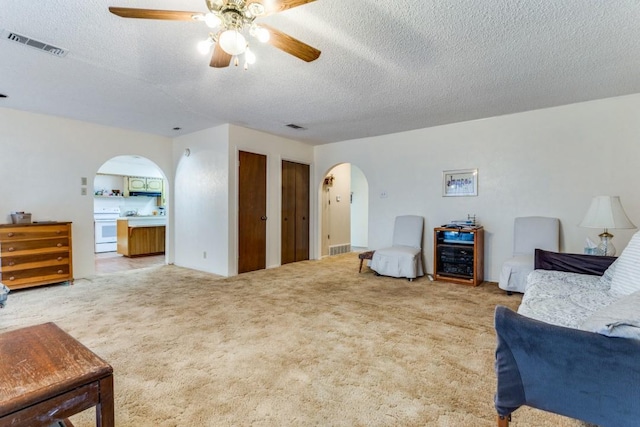 sitting room with ceiling fan, carpet flooring, and a textured ceiling