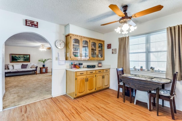 kitchen with ceiling fan, a textured ceiling, and light wood-type flooring