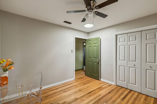 unfurnished bedroom featuring ceiling fan, light hardwood / wood-style floors, and a closet