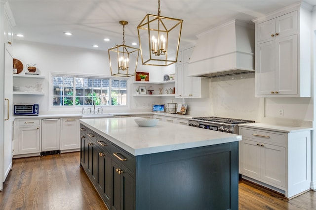 kitchen with pendant lighting, custom range hood, white cabinets, and a kitchen island