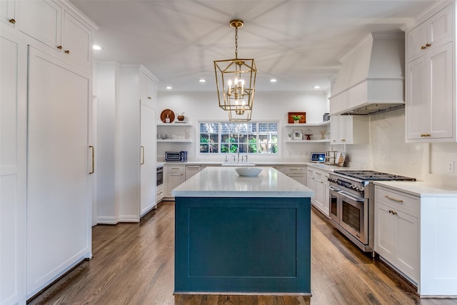 kitchen with custom exhaust hood, decorative light fixtures, a center island, double oven range, and white cabinets