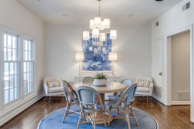 dining room featuring an inviting chandelier, crown molding, and dark wood-type flooring