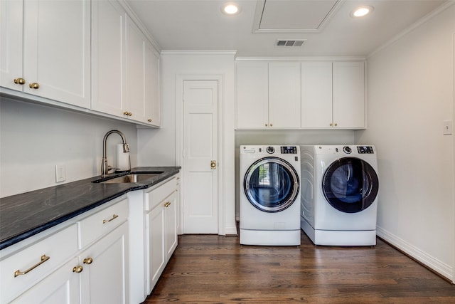 laundry area featuring sink, crown molding, dark hardwood / wood-style floors, cabinets, and washing machine and clothes dryer