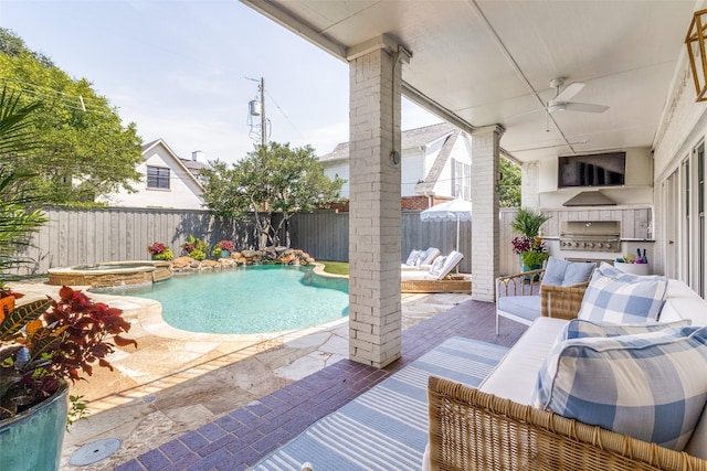 view of pool with a patio area, area for grilling, an in ground hot tub, ceiling fan, and exterior kitchen