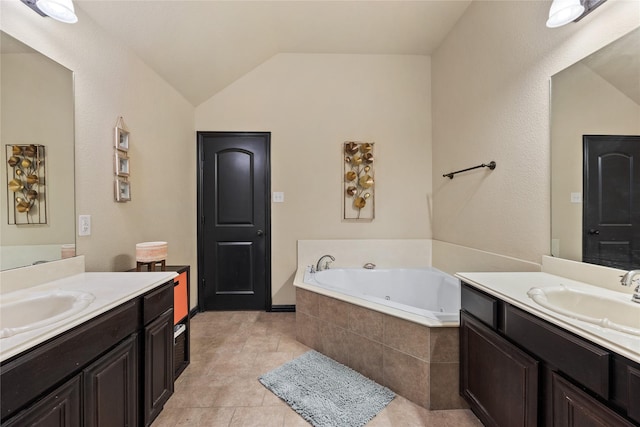 bathroom with a relaxing tiled tub, vanity, vaulted ceiling, and tile patterned floors