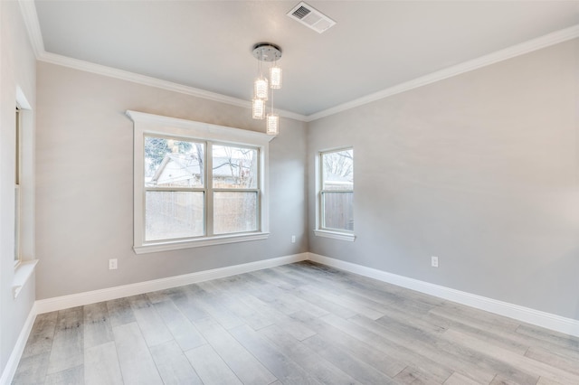 spare room with ornamental molding and light hardwood / wood-style flooring